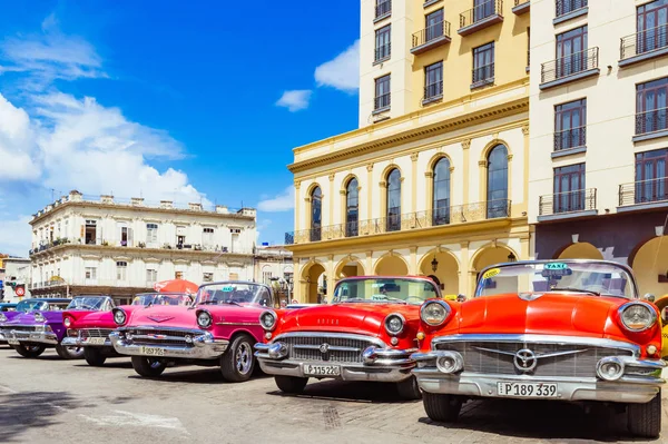 Havana, Kuba - 3. října 2018: Americká červená 1955, 1956 Buick Century kabriolet, růžová 1957 Chevrolet Bel air convertible and a 1958 Ford Fairlane convertible vintage cars parking in row in the old Stock Fotografie