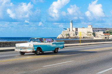 Havana, Küba - Ekim 03, 2018: Amerikan mavi 1959 Ford Fairlane model araba Malecon gezinti güvertesinde ve arka planda Castillo de los Tres Reyes del Morro Havana City Küba - Serie 