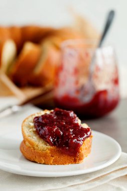 Kahvaltıda beyaz tabakta portakallı turuncu meyveli kek ve ahşap masa. Kahvaltı ya da tatlı için geleneksel ev yapımı pasta. Pound Cake