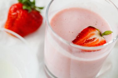 Organik probiyotik süt kefir içeceği ya da beyaz gri arka planda çilekli yoğurt. Probiyotik soğuk mayalanmış süt içeceği. Moda süper yiyecekler