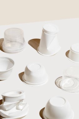 Beyaz arka planda plastik atık bardağının yaratıcı bileşimi. Çevre kirliliği kavramı