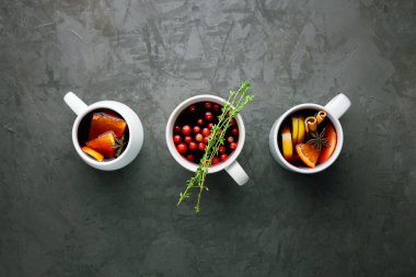 Noel sıcak şarap ya da gluhwein portakal, elma, tarçın çubukları ve koyu gri arka plan fotokopi alanı üzerinde anason içeren bardaklarda içilir. Kış tatili için geleneksel içecekler.