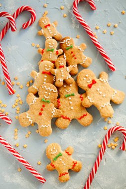 Noel ağacı bisküvilerden, zencefilli kurabiye adam kurabiyeleri ve açık mavi arka planda baston şekerlemelerden yapıldı. Güzel yemekler. Noel ve yeni yıl gelenekleri.