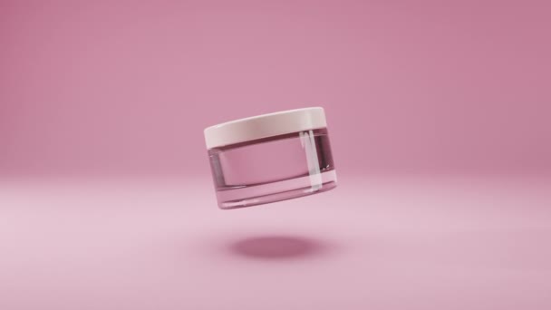 Glazen cosmetische lege pot met witte deksel op een geïsoleerde roze achtergrond. Fles draait langzaam in de lucht. Vrouwen cosmetica huidverzorging. Voorbeeld van de lay-out van het pakket schoonheid product. Realistische 3D-animatie — Stockvideo