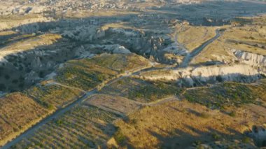Kapadokya, Türkiye 'deki muhteşem manzara. Ulusal parktaki dağlarda uçan insansız hava aracı görüntüleri. İnanılmaz kum taşı oluşumları. Gün batımında resim gibi görünüm.