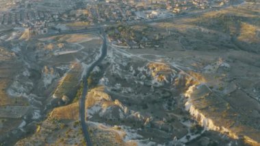 Şehrin güneşli manzarası, kuşların gözünden geniş tepeler ve kapadokya dağları. Türkiye 'de inanılmaz arazi, mağaralar ve geçitler, üzüm bağları, tarlalar ve otlaklar, evler ve yollar.