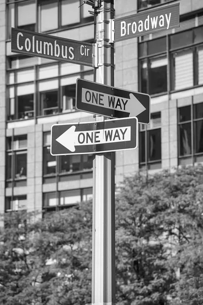 Black and white picture of Broadway and Columbus Circle street name signs, New York City, USA.