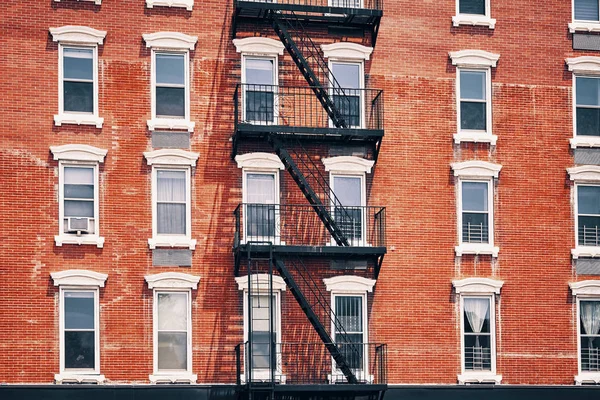Oude rode bakstenen gebouw met fire escapes, New York City. — Stockfoto