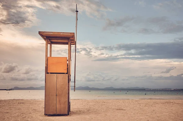 Torre de salvavidas en una playa vacía al atardecer . — Foto de Stock