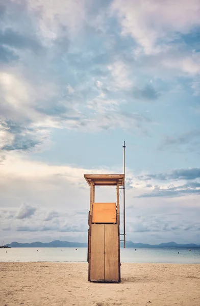 Torre di bagnino su una spiaggia vuota al tramonto . — Foto Stock