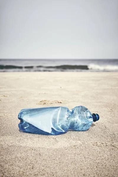 Lege plastic fles op een strand. — Stockfoto