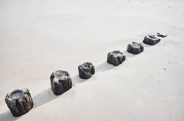 Vieux brise-lames en bois restant dans le sable . — Photo