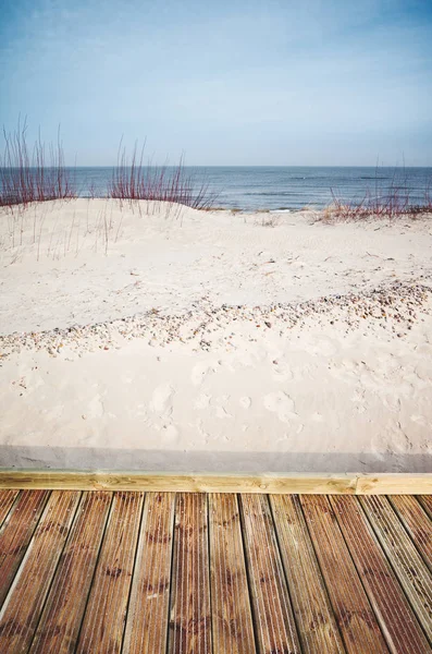 Vista de un paseo marítimo de madera junto a una playa . — Foto de Stock