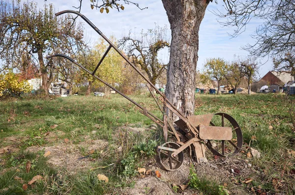 Vieja máquina de siembra apoyada en un árbol . — Foto de Stock