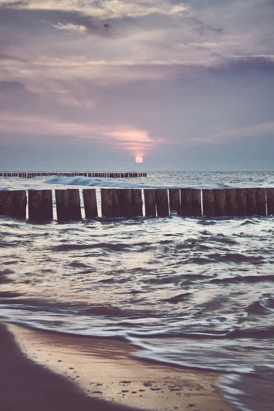 Wooden sea breakwater at sunset. — Stock Photo, Image
