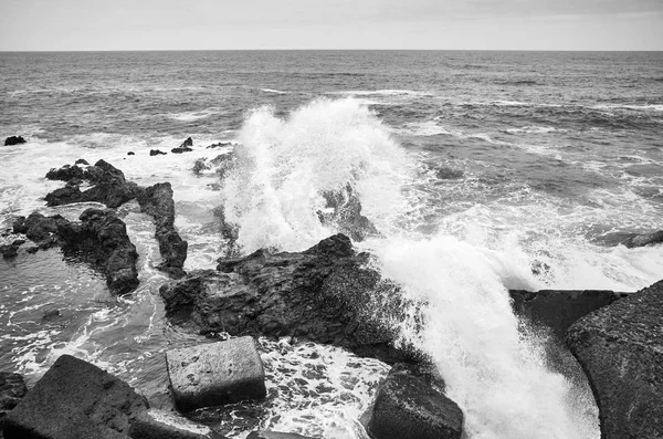 Black and white picture of waves crashing on rocks. — Stock Photo, Image