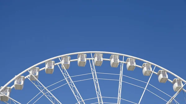 Panoramisch uitzicht op een reuzenrad tegen de blauwe hemel. — Stockfoto