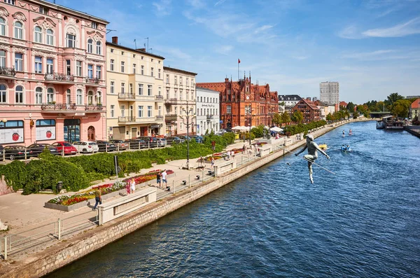 Bydgoszcz cityscape seen from a bridge with tightrope walker sculpture over Brda River. — Stock Photo, Image