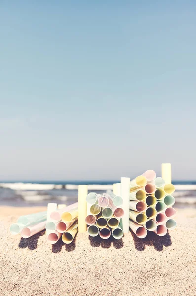 Las pilas de las pajitas de plástico en la playa . — Foto de Stock