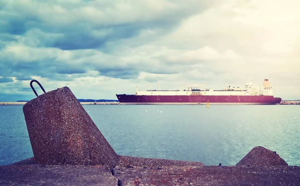 Betonová vlnolamy s tankerem Lng ve vzdálenosti při západu slunce. — Stock fotografie