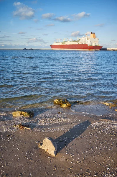 Beach with LNG tanker in distance at sunset. — Stock Photo, Image