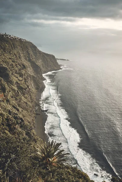 Playa volcánica vista desde un acantilado al atardecer . — Foto de Stock