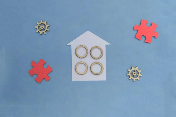 House, gears, puzzles on a blue background. Realty. share ownership. Housing market.