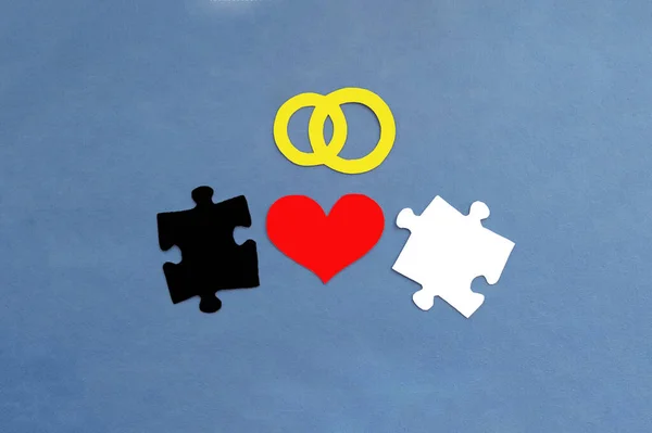 結婚指輪のペア 白と黒の2つのパズル 青の背景に赤いハート 婚姻契約 — ストック写真