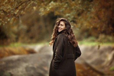 Parkta yürüyen güzel mutlu bir kız. Portre. Moda, tre