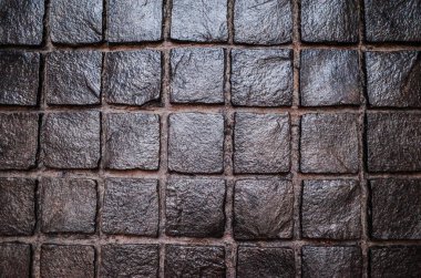 Işık doku arka plan yansıması olan siyah Arnavut kaldırımlı taş yol.