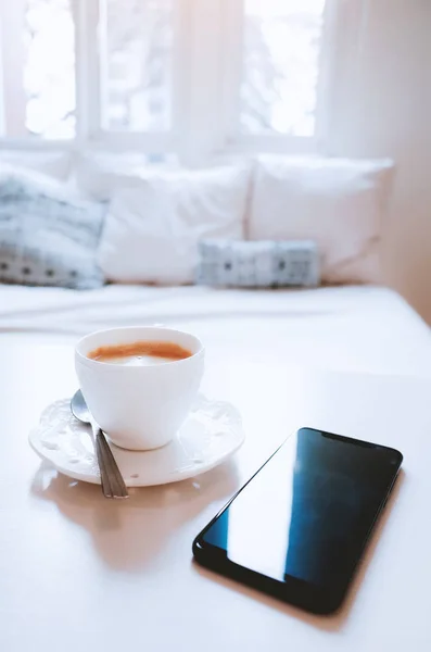 Hareket eden telefon ile kahve'de bir tabloda yatak odası — Stok fotoğraf