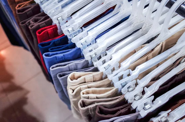 Multi colored clothing hanging on hangers — Stock Photo, Image
