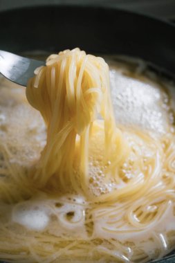 Genç kadınlar evde spagetti hazırlıyorlar.