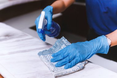 Ev masasını temizlemek mutfak masasının yüzeyini dezenfektan sprey şişesiyle temizlemek yüzeyi havlu ve eldivenle yıkamak. COVID-19 önleme içeride dezenfekte ediliyor