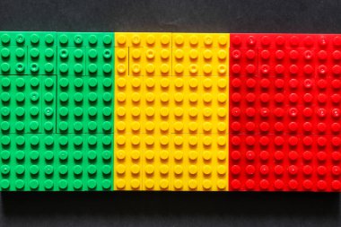 Plastik oyuncak bloklar yeşil sarı kırmızı arka plan üzerinde