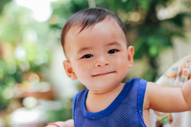 Bebek gülümseyen ve kamera açık havada güneş ışığında arıyorsunuz