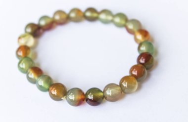 Thee renkli yeşim bilezik muska, bilezik beyaz bir arka plan üzerinde doğal taşlardan yapılmış tarafından iyi bir servet ve zenginlik ek