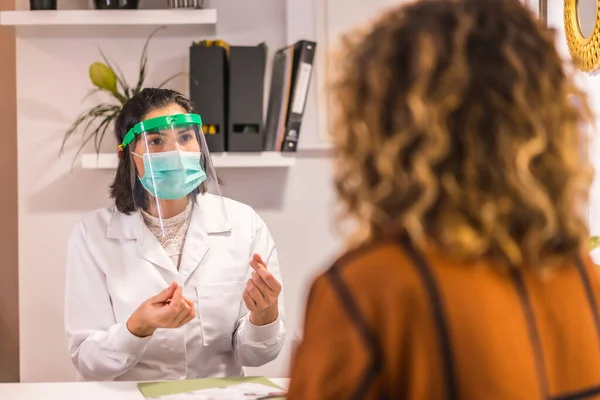 美容院在大脑皮层病毒大流行后重新开张并采取安全措施女医生在谈话中戴着护目镜和面罩 Covid — 图库照片