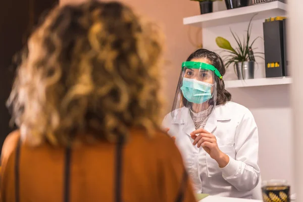 美容院在大脑皮层病毒大流行后重新开张并采取安全措施女医生带着护目镜和面罩解释预算 Covid — 图库照片