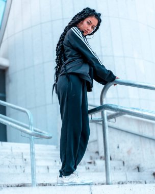 Dansçıyı tuzağa düşürmek için yapılan şehir seansı, Latin kökenli, uzun örgülü, siyah kazaklı, beyaz korkuluklu beyaz apolllada 'lı bir esmerle.