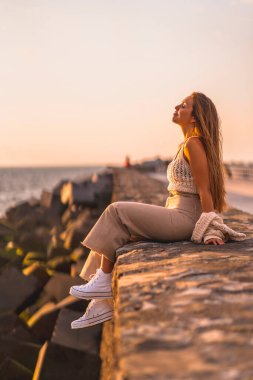 Yaz yaşam tarzı. Gün batımında sahilde genç bir kadının portresi..
