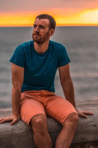 Muotokuva Komea Mies Rentouttava Meren Rannalla Auringonlaskun Aikaan — kuvapankkivalokuva