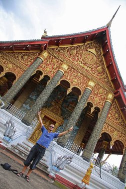 Luang Prabang, Laos - Ağustos 2017: Luang Prabang 'daki etkileyici Wat Xieng tangasında genç bir adam