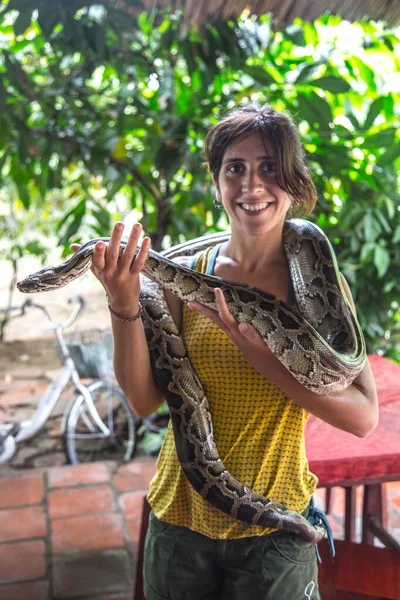 woman posing with big snake in jungle