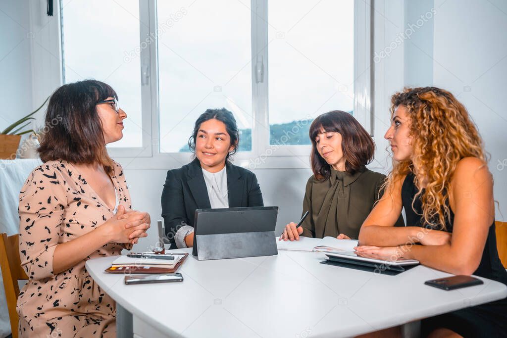 four female colleagues communicating in office 