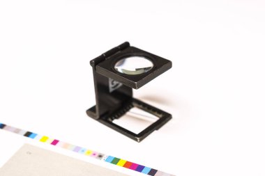 Ofset Press 'te fotoğraf çekimi. Mürekkeple CMYK, Cyan, morumsu, sarı ve siyah. Grafik sanatı, ofset baskı. Kontrol bantları üzerinde iplik tezgahı ayarlama aracı