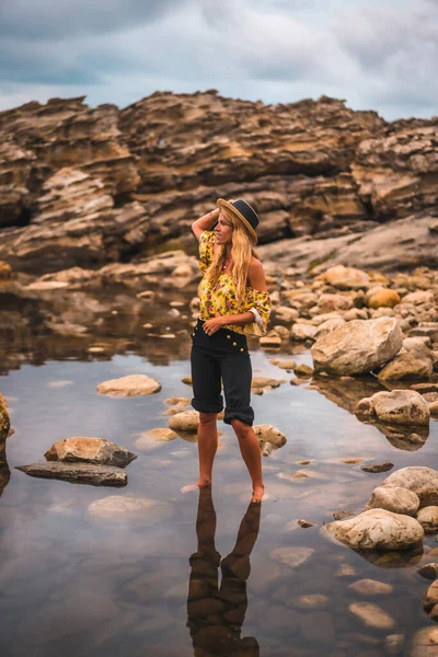 Vrouw Hoed Poseren Zee Kust Met Grote Rotsen — Stockfoto