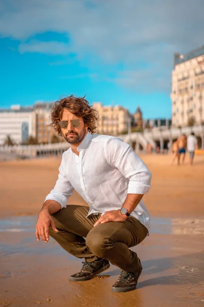 Uvolněný Muž Bílé Košili Sluneční Brýle Sedí Písečné Pláži Proti — Stock fotografie