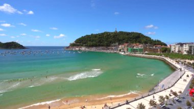 San Sebastian şehrindeki La Concha plajı, yukarıdan bakıldığında insansız hava aracı manzaralı. Donostia. Gipuzkoa, İspanya. 4K video. Bir yaz öğleden sonra ve arka planda güzel bir şehir