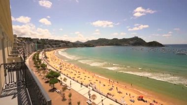 San Sebastian şehrindeki güzel La Concha plajı, yukarıdan bakıldığında insansız hava aracı manzaralı. Donostia. Gipuzkoa, İspanya. Onu sağdan soldan dengeleyerek izliyordu.